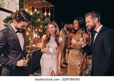 Group Of Beautiful People In Formalwear Communicating And Smiling While Spending Time On Luxury Party