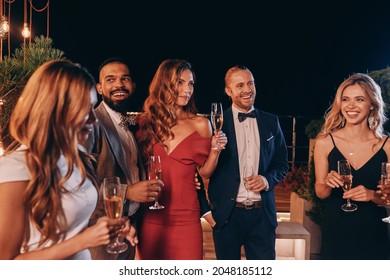 Group of beautiful people in formalwear communicating and smiling while spending time on luxury party - Shutterstock ID 2048185112