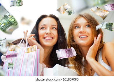 Group Of Beautiful Shopping Women With Bags And Smiling. Money Flying Around Them. Spending Money Non Stop Concept