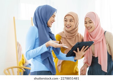 Group of a beautiful smart Asian muslim woman standing in the room and having a discussion together. Modern muslim society concept, women muslim student talking. - Powered by Shutterstock