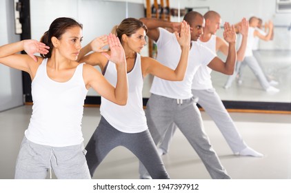 Group of beginners mastering martial arts for self defence, synchronously repeating basic movements in gym.. - Powered by Shutterstock