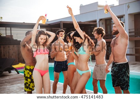 Group of best friends having fun dancing at swimming pool outdoors