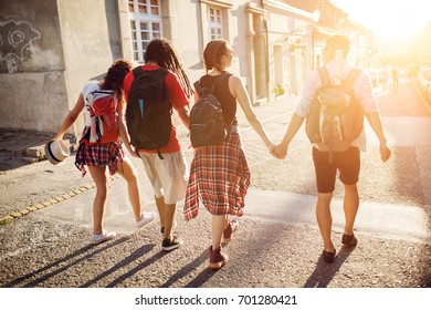 Group Of Best Friends Are Holding Hands Touring The City.