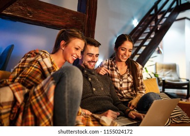 Group Of Best Friends Sitting At Home On Pleasant Evening And Watching A Movie On Laptop.