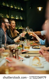 Group Of Best Friends Sitting In Restaurant, Making A Toast And Celebrating.