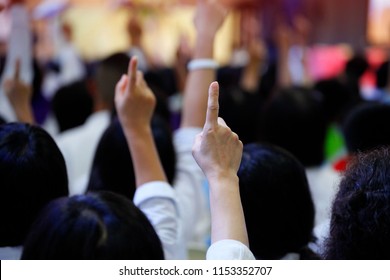 Group of bidders raise up their fingers to bid or make auction. Business people in meetings, conferences or seminars show  hands for vote or ask question among crowd, democracy and election concept