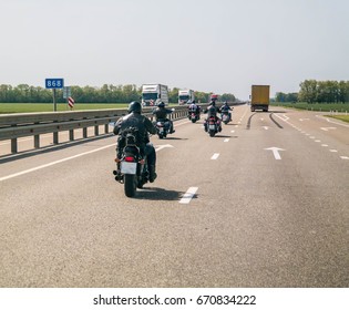 A Group Of Bikers Are Driving Along The Highway