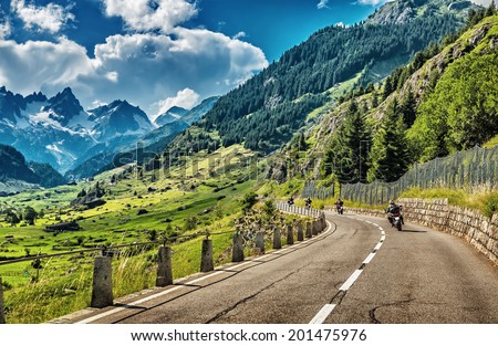 Group of bikers touring European Alps, motorcyclists on mountainous road, enjoying ride, summertime activities, wonderful mountain landscape, extreme activities, freedom vacation concept 
