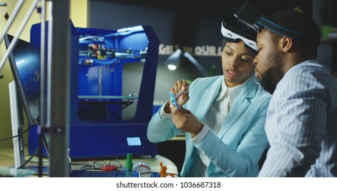 Group of black coworkers in laboratory wearing VR goggles and exploring 3d printing model and check quality of printed product. - Powered by Shutterstock