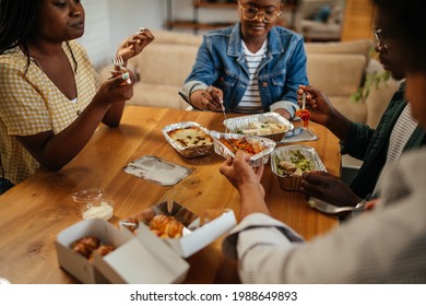 Group Of Black Friends Eating Takeout Food At Home. They Are Chatting And Having A Relaxing Lunch Time Together