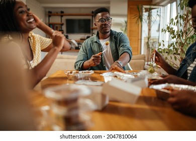 Group Of Black Friends Eating Takeout Food At Home. They Are Chatting And Having A Relaxing Lunch Time Together