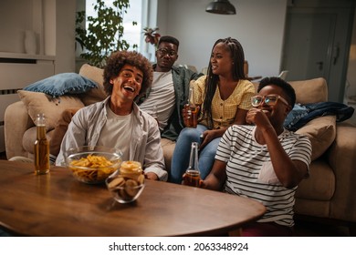 Group Of Black Friends Watching Tv In Living Room And Drinking Beer