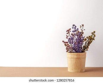 Group of bouquet dried and wilted multiple color Gypsophila flowers in wood bucket on brown floor and white background - Shutterstock ID 1280257816