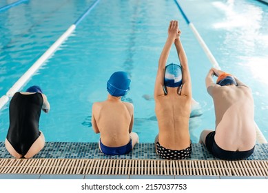 Un grupo de niños y niñas entrenan y aprenden a nadar en una moderna piscina con un instructor. Desarrollo de deportes para niños. - La educación de los hijos y la promoción de los deportes infantiles.