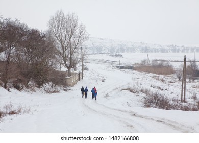 group of boys going on the snowy country road  