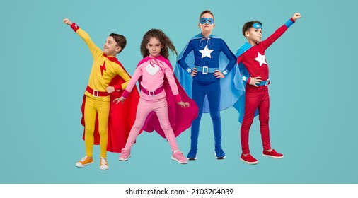 Group of brave superhero children in bright costumes standing together on blue background in studio