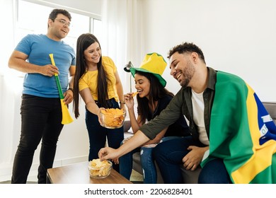 Group Of Brazilian Friends Watching A Football Match On TV