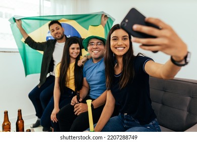 Group Of Brazilian Friends Watching A Football Match On TV