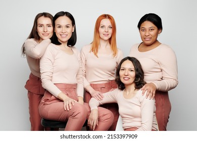 Group Of Bright And Confident Multi-ethnic Ladies In Same Outfit Posing Together Against Isolated Background