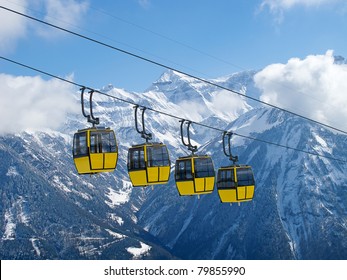 Group Of Bright Yellow Cable Car Cabins In Swiss Alps