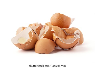 Group of broken eggshells stacked isolated on a white background. Eggshells are oval, brown, brittle and thin, easily broken.