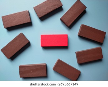 Group of brown rectangular blocks with red in the middle on blue background. Copy space for word or text.