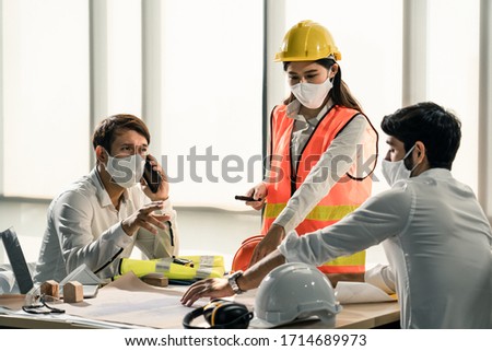 Group of building architect construction engineer have meeting and brainstorm together on table discussing about new project, teamwork talk with colleague. Members wear face mask prevent covid19 virus