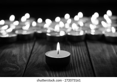 Group of burning candles on  black background. Black and white