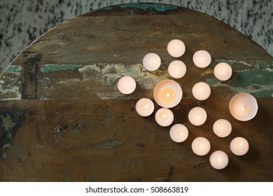 Group of Burning Tea Lights on a dark wooden surface.  - Powered by Shutterstock