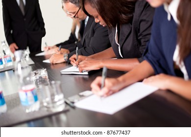 Group Of Business Executives Taking Notes During A Meeting At Office