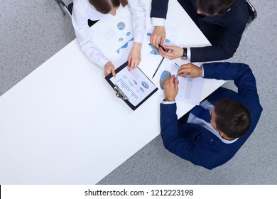 Group Of Business People Analyzing Financial Documents, View From Above. Business Team At Meeting