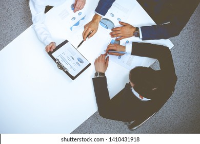 Group Of Business People Analyzing Financial Documents, View From Above. Business Team At Meeting