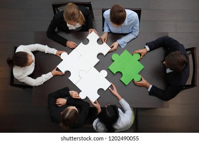 Group of business people assembling jigsaw puzzle, team support and help concept