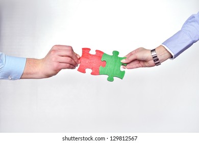 Group of business people assembling jigsaw puzzle and represent team support and help concept - Shutterstock ID 129812567