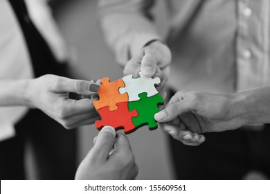 Group of business people assembling jigsaw puzzle and represent team support and help concept - Shutterstock ID 155609561