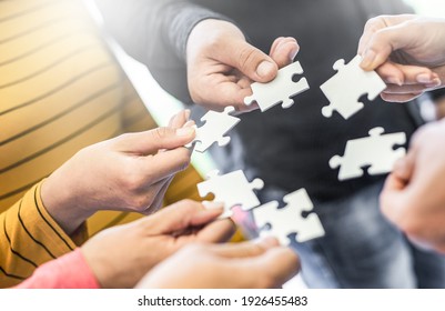 A group of business people assembling jigsaw puzzle. The concept of cooperation, teamwork, help and support in business.