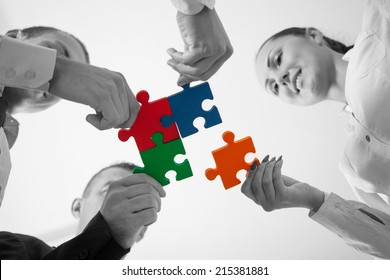 Group Of Business People Assembling Jigsaw Puzzle And Represent Team Support And Help Concept In Office