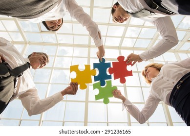 Group of business people assembling jigsaw puzzle and represent team support and help concept.