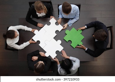 Group Of Business People Assembling Jigsaw Puzzle, Team Support And Help Concept