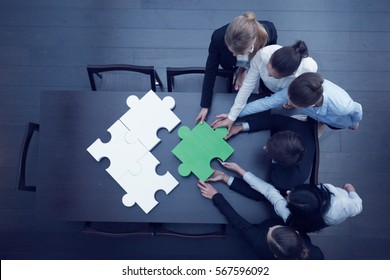Group of business people assembling jigsaw puzzle, team support and help concept - Shutterstock ID 567596092