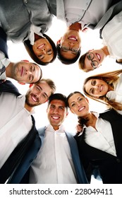 Group Of Business People In A Circle Looking Down