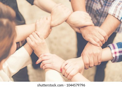 Group of business people crossed arms in pile for win. Stack of hands. Cooperation concept - Shutterstock ID 1044579796