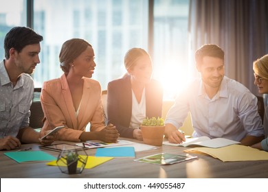 Gruppe der Geschäftsleute, die am Schreibtisch im Büro diskutieren