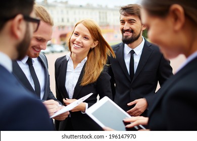 Group Of Business People Discussing Ideas At Meeting Outside