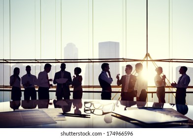 Group Business People Discussing at Sunset Reflected Onto Table and Documents 