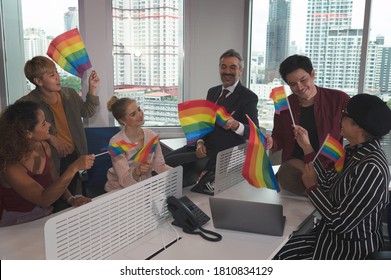 Group Of Business People With Diverse Genders (LGBT) Celebrate LBGT Freedom And Support With LGBT Flag In The Meeting Room At Office Workplace