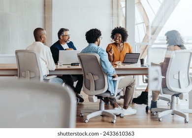 Group of business people engaged in a lively discussion and brainstorming session. They work collaboratively, sharing ideas and smiling with enthusiasm. Shows professionalism and teamwork. - Powered by Shutterstock