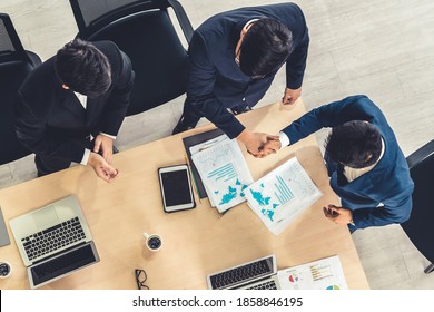 Group business people handshake at meeting table in office together with confident shot from top view . Young businessman and businesswoman workers express agreement of investment deal. - Shutterstock ID 1858846195