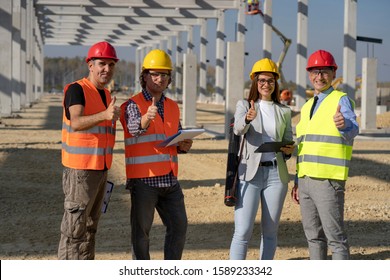 Group Of Business People In Hardhats With Thumbs Up On Construction Site.Project Management And Field Crew Meeting On Construction Site. Supervisor, Female Architect , Foreman And Construction Worker.