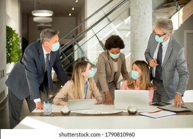Unternehmensgruppen treffen sich und arbeiten im Büro und tragen Masken als Schutz vor dem Corona-Virus